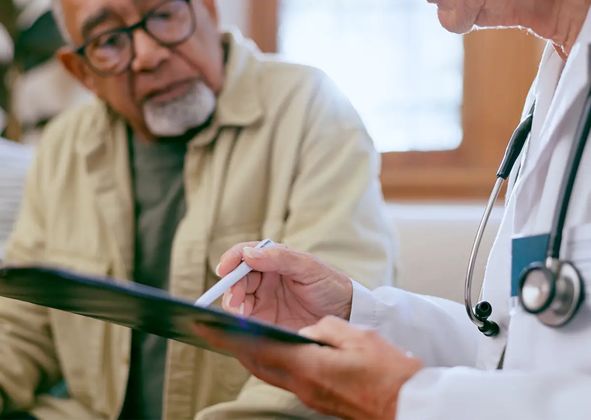 elderly man going over paperwork with doctor